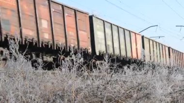 Yük treni, güneşli bir günde, yakın mesafeden demiryolunda ilerliyor.