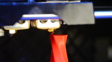 Zaman ayarlı çok güzel 3D yazıcı yakın çekim makrosu basıyor. Karşıt görüntüler. 3D yazıcı ve katman modelinde sıcak plastik tel filament. Sesle. Siyah arka planda kırmızı plastikle izole edilmiş bir model.