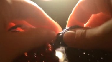 Kadın bir iplik örme yün ürünleri çeker ve siyah arka plan üzerine örme çözülüyor ışık lambaları, yakın çekim. Konu mavi ve kırmızı renk. Parmak ve çivi yakın çekim