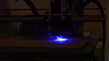 Ahşap oyma lazer. 3D yazıcı lazer ışını bir ahşap tahta üzerine desen yakın çekim yakar. Endüstriyel Modern teknolojik arka plan. Mavi lazer 3d printerlere harcama maddeler taşır bir ahşap yüzey yanıkları kelimeleri