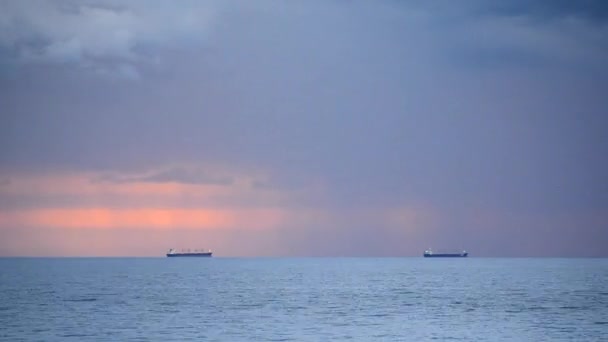 一艘谷物运输船在地平线上远离海面 背景是黎明的落日 雨下着 乌云密布 自然背景 时间流逝 — 图库视频影像