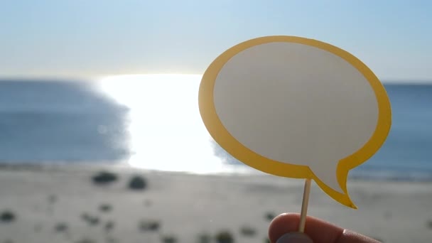 在阳光明媚的夏日 随手拿着纸在蓝海 沙滩上空谈 带有文本空间的文本气球 旅游度假度假度假的概念 — 图库视频影像