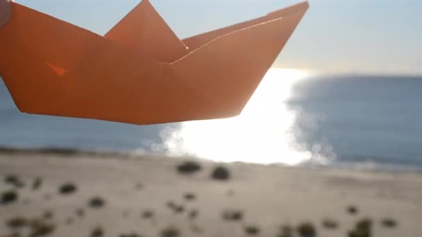 Mavi Gökyüzünün Arka Planında Turuncu Kağıttan Bir Tekneyle Oynayan Güneşli — Stok video