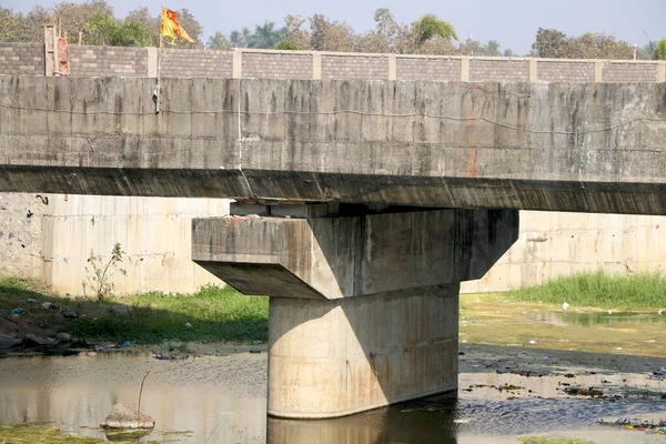 Nehir üzerindeki beton köprü ve su üzerindeki yosunların manzarası