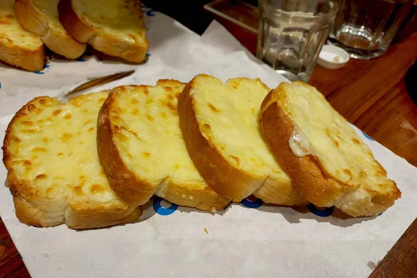 cheese garlic bread served on wooden table in restaurant