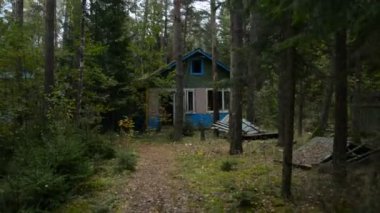 Ormanda terk edilmiş ahşap evlerin arasında yürümek, kıyamet konsepti.