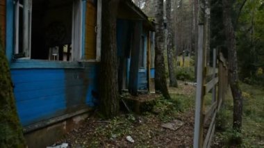 Ormanda terk edilmiş ahşap evlerin arasında yürümek, kıyamet konsepti.