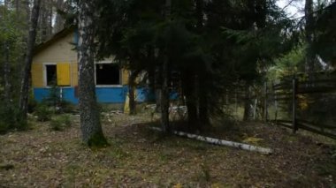 Ormanda terk edilmiş ahşap evlerin arasında yürümek, kıyamet konsepti.