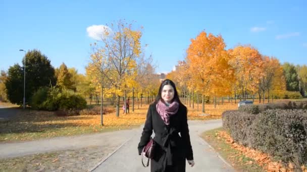 Szczęśliwy stylowa dziewczyna w czarny płaszcz spacery w jesiennym mieście — Wideo stockowe