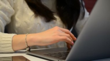 Dizüstü bilgisayarda çalışan ve klavyede yazan bir iş kadını