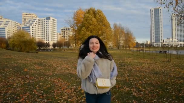 Een jong meisje wandelt 's avonds in het herfststadspark — Stockvideo