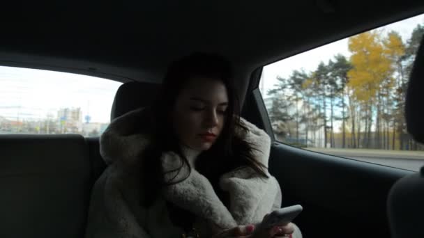 Zbliżenie kobiety ręce czat jej komórka siedzi w taksówce — Wideo stockowe