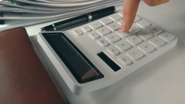 White calculator close on desk in office — Stockvideo