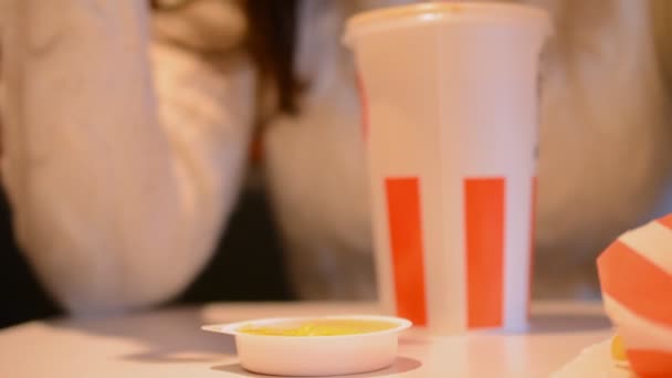 Chica comiendo papas fritas en un restaurante de comida rápida — Vídeo de stock