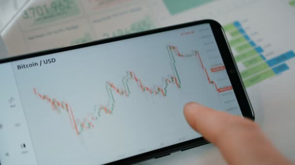 Empresario está analizando y prediciendo Bitcoin gráfico de precios en el intercambio digital en la pantalla del teléfono móvil — Vídeos de Stock