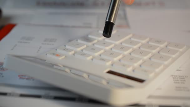 Osoba używająca podstawowego standardowego białego kalkulatora do sporządzania raportów finansowych — Wideo stockowe