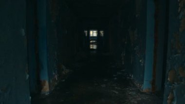 Walking down long corridor in abandoned building