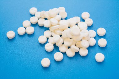 Antidepressant pills on blue background close up