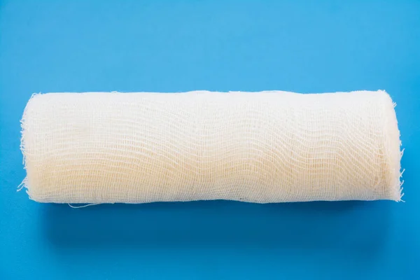 Mavi arka planda beyaz tıbbi bandaj — Stok fotoğraf