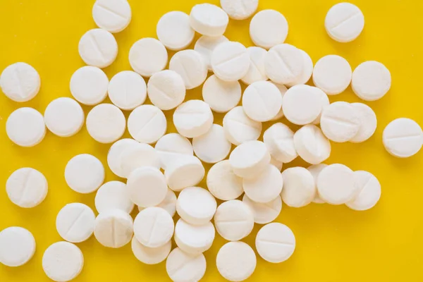 白い痛み救済薬ヒープ上の黄色の背景 — ストック写真