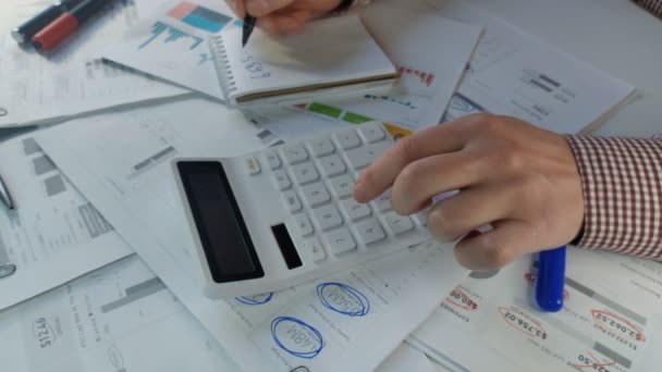 Аналитик рассчитывает данные о финансовой прибыли компании на калькуляторе — стоковое видео