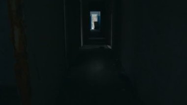 Terk edilmiş bir binada karanlık bir koridorda yürüyorum.