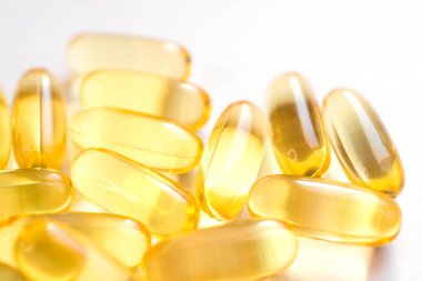 Omega 3 vitaminleri, sarı kapsüller kapanıyor, balık yağı.