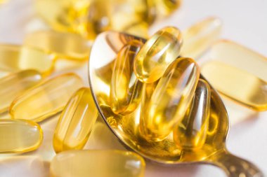 Omega 3 vitaminleri, sarı kapsüller kapanıyor, balık yağı.