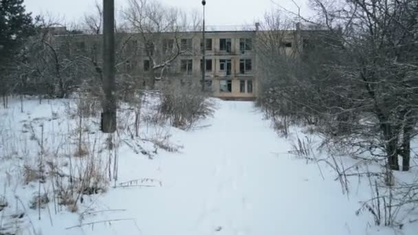 雪の中放棄された建物に向かって歩く ロイヤリティフリーストック映像