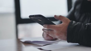 Akıllı telefon, içerideki evrakları dolduran adamın elinde.