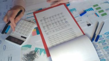 Ofis masasında çalışan ve mali raporlarda grafik ve çizelgeleri analiz eden bir işadamının ellerini kapat.