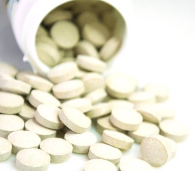 Kafein tabletleri beyaz arkaplanda izole bir şekilde kayar