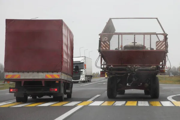 Zeltlaster Überholt Traktoranhänger Auf Fußgängerüberweg Auf Der Osteuropäischen Vorstadtstraße Herbsttag — Stockfoto