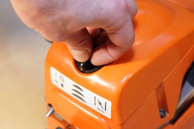 Sarı testere hava filtresi kapağı, bir adamın eli kapalı, güvenlik için elektrikli aletler denetimi