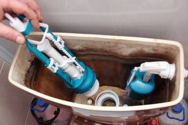 Eski seramik kahverengi tuvalet suyu tankına yeni tesisat kurulumu. Kapatın, DIY WC tamiri yapın.
