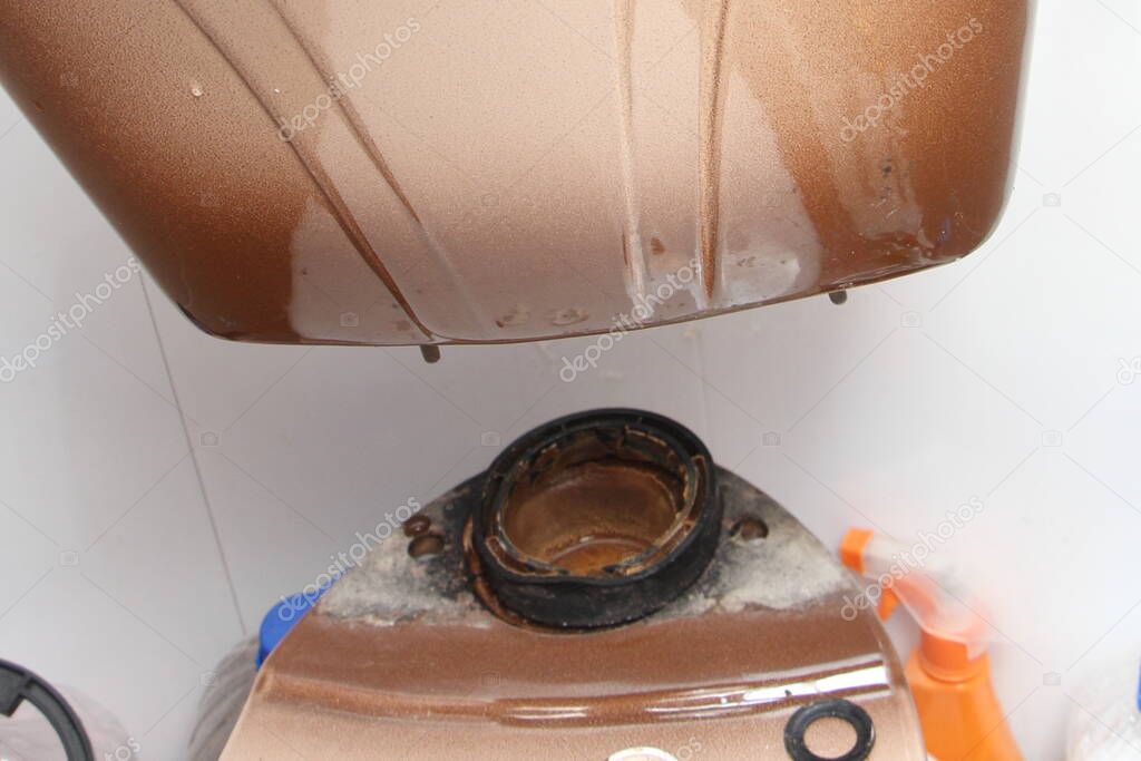 Removing the old dirty drain water tank closeup from the toilet seat - DIY WC repair at home