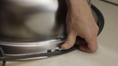 Yeni paslanmaz çelik mutfak lavabosunun üzerine yapışkan bir mühür yerleştirildi.