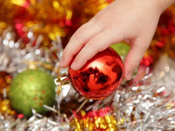 Χριστουγεννιάτικη Διακοσμητική Κόκκινη Μπάλα Λευκό Παιδί Χέρι Closeup Χρωματιστό Φόντο — Φωτογραφία Αρχείου