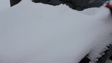 Araba kaputundan kar fırçalamak - kar yağdıktan sonra araç sürmeye hazırlanmak