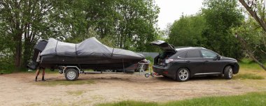 Tek dingil teknesi olan hibrid SUV hibrit araba kumlu yolda teknenin römork tarafında. Avrupa 'da aktif Watercraft eğlencesi.