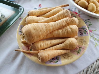 Arka plandaki havuçlar genellikle Noel ve Şükran Günleri 'nin şenlik sezonunda akşam yemeğiyle kızartılmış olarak servis edilir.