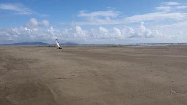 Pembrey, Wales, UK, August 11, 2021 : Windsurfer practising the land windsurfing sailing or terrasailing sport on Cefn Sands at Pembrey Country Park in Carmarthenshire South Wales, video footage clip