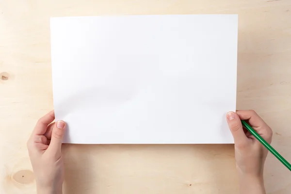 Beyaz kağıt ve tahta masada iki kolu.