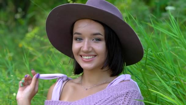 Retrato de una joven morena feliz con sombrero en un soleado día de verano — Vídeos de Stock