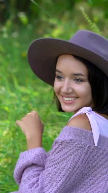 Dikey video: Bir yaz günü şapkalı esmer bir kadının portresi