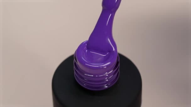 Gel polonês violeta textura grossa. O verniz flui de uma escova em um tubo preto — Vídeo de Stock