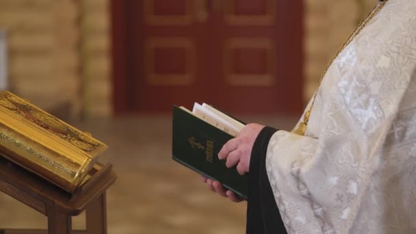 Close-up van de handen van de priesters met de Bijbel. De Heilige Vader leest een gebed voor — Stockvideo