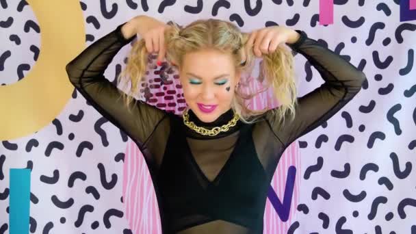 Glada blond kvinna med ljusa makeup och färgglada manikyr vidrör hennes hår — Stockvideo