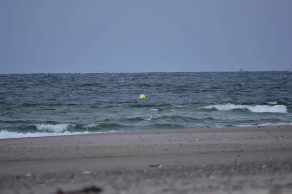 海滩对着大海的不同焦点，有一个小小的漂浮浮标 — 图库照片
