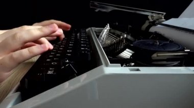 Kız retro bir daktiloyla daktilo yazıyor..